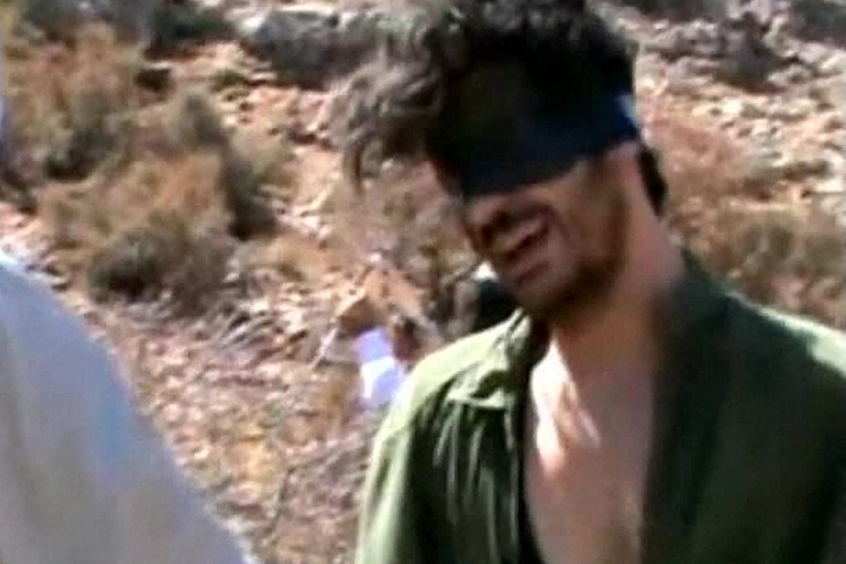 An image grab taken from a video on YouTube on October 1, 2012, shows American freelance journalist Austin Tice blindfolded with men believed to be his captors at an undisclosed location in Syria.