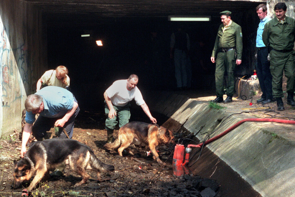Polizeibeamte mit Hunden suchen am 31.03.1998 im Liederbach in Frankfurt-Höchst nach Spuren des ermordeten 13-jährigen Tristan.