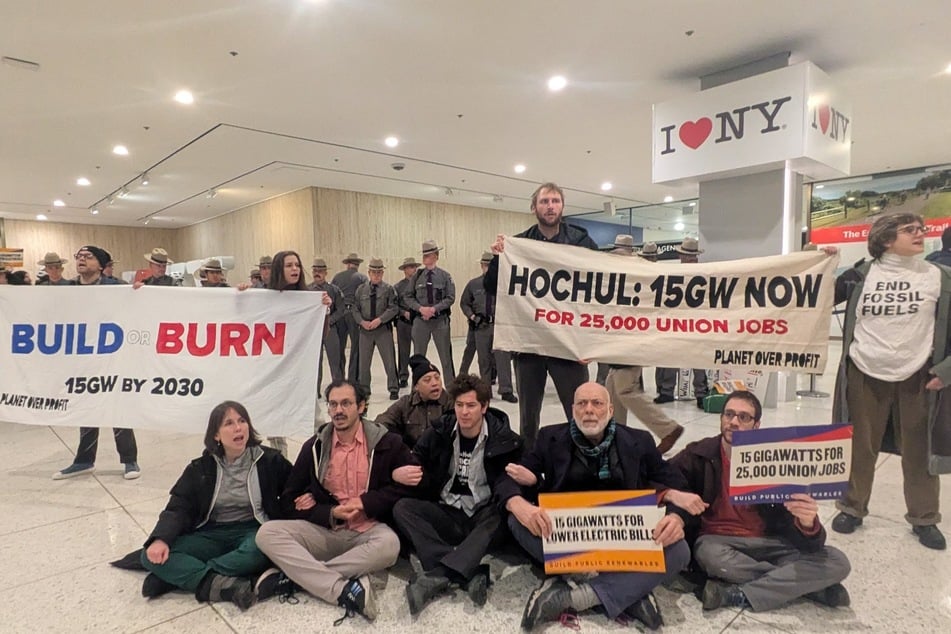 Climate activists rally outside New York Governor Kathy Hochul's State of the State address.