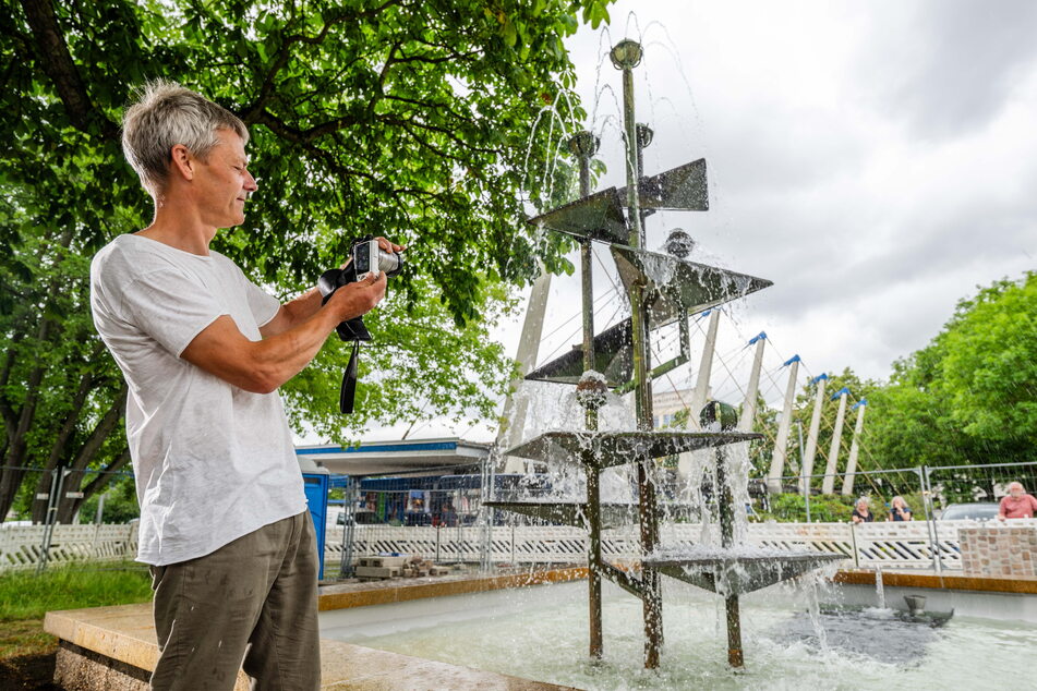 Der Brunnen sprudelt wieder wie früher. Erik Neukirchner (50) dokumentiert den Abschluss seiner Arbeit.