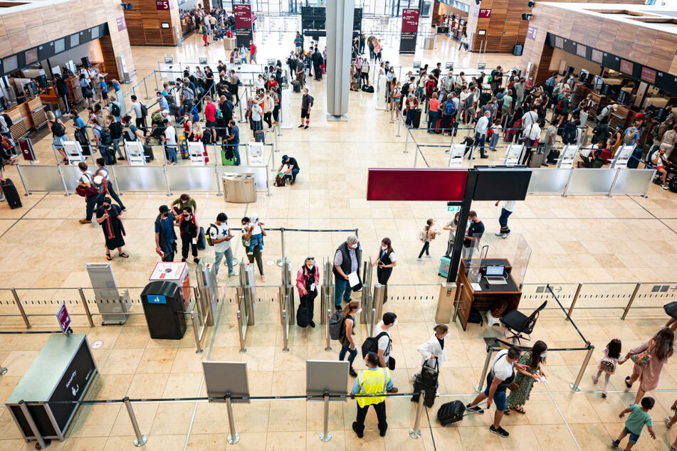 Fluggäste warten in der Haupthalle des Flughafens Berlin-Brandenburg. Der BER hat bei einer Umfrage unter den Fluggästen besser abgeschnitten als der ehemalige Flughafen Tegel.