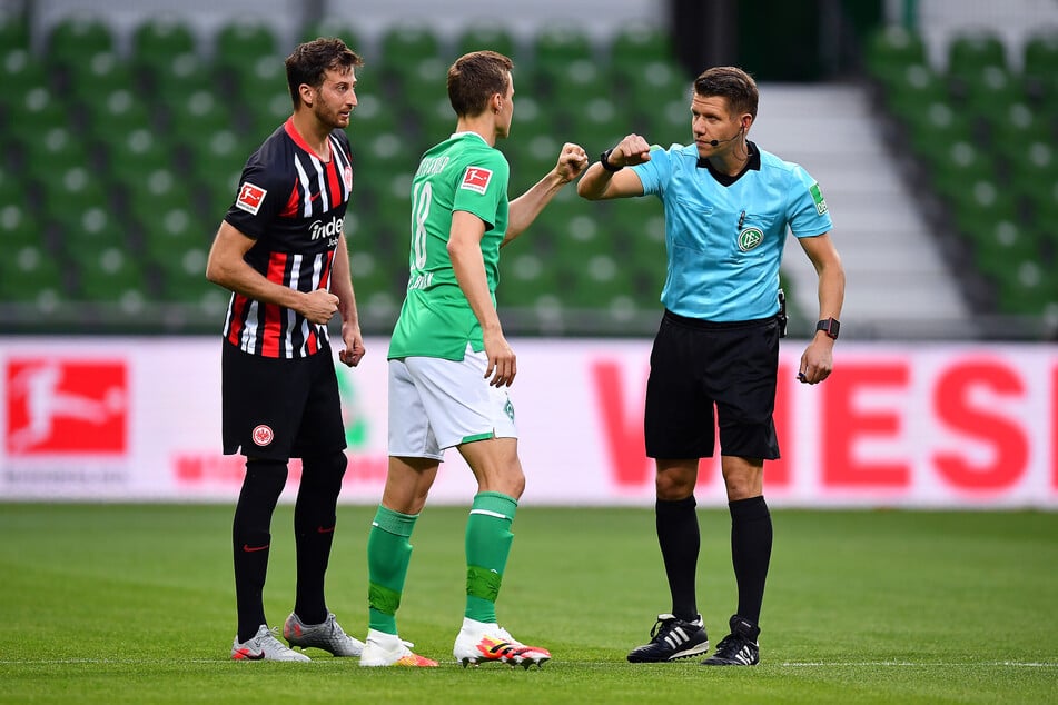 Eintracht Frankfurts Kapitän David Abraham (l.), Bremens Niklas Moisander (m.) und Schiedsrichter Patrick Ittrich.