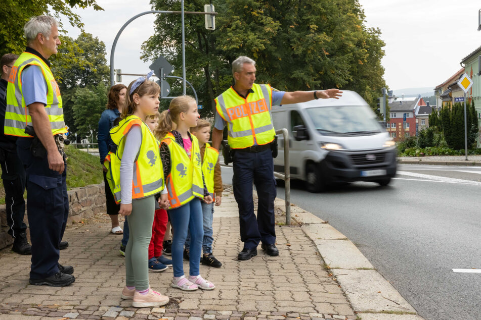 Uwe Huster erklärt den Kindern, wo und wie sie über die Straße gehen müssen.