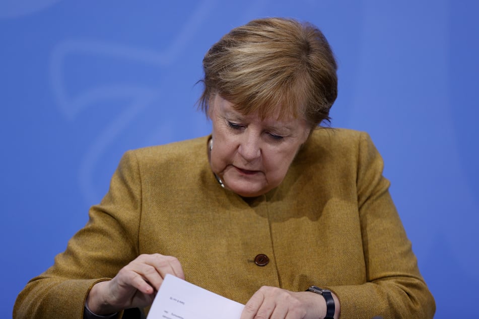 Bundeskanzlerin Angela Merkel (CDU) schaut in der Pressekonferenz in ihre Unterlagen.