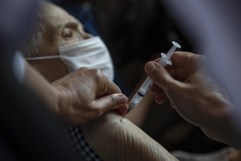 Ein älterer Mann wird gegen das Coronavirus geimpft. Die gemeldeten Nebenwirkungen des Corona-Impfstoffs weichen bislang nicht signifikant von anderen Impfstoff-Meldungen ab.