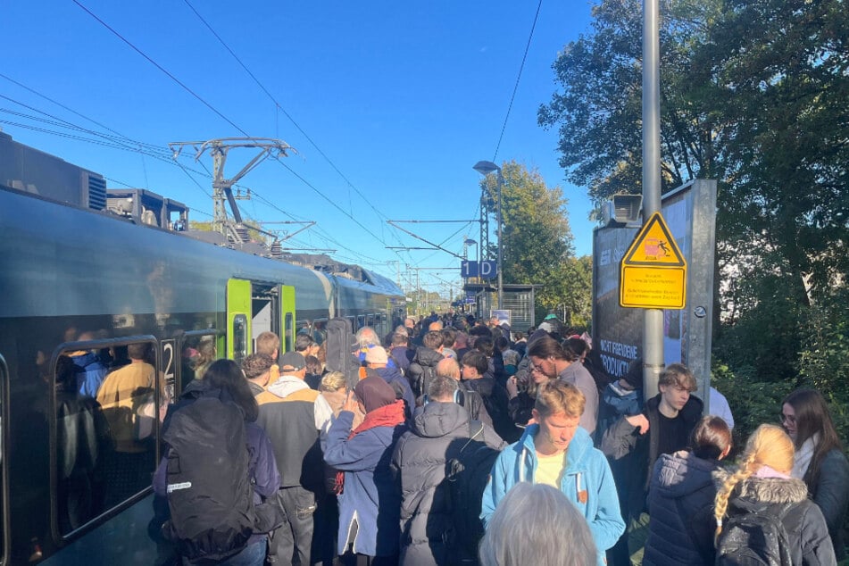 Menschen stehen an einem überfüllten Bahnsteig in Elmshorn.