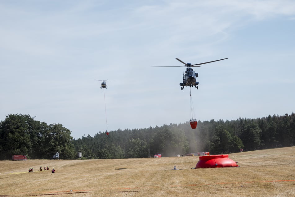 Die Löscharbeiten der Feuerwehr werden von vier Hubschraubern aus Luft unterstützt.