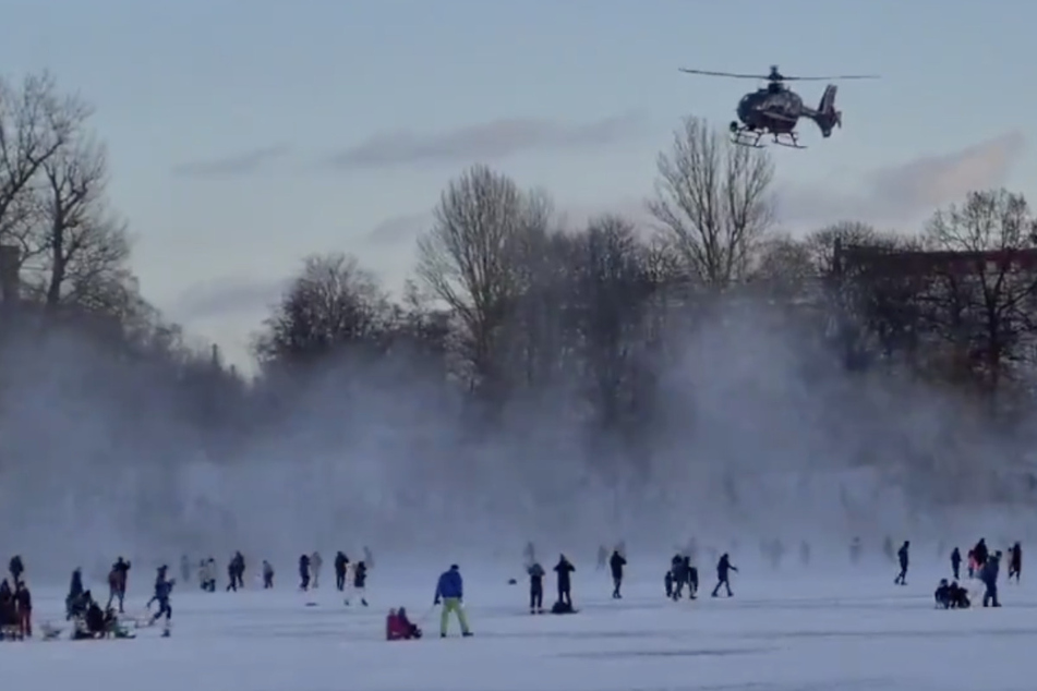 Ein Polizeihubschrauber vertreibt die Menschen auf dem zugefrorenen Weißen See.