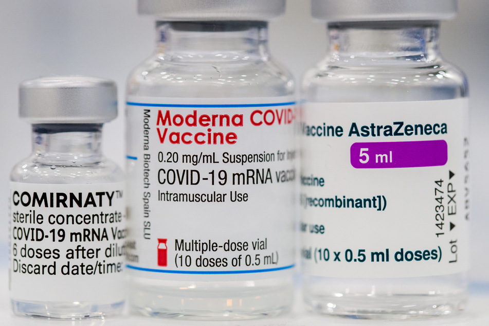 Ein Fläschchen der Corona-Impfstoffe von Pfizer-BioNTech (l-r), Moderna und AstraZeneca stehen auf einem Tisch.