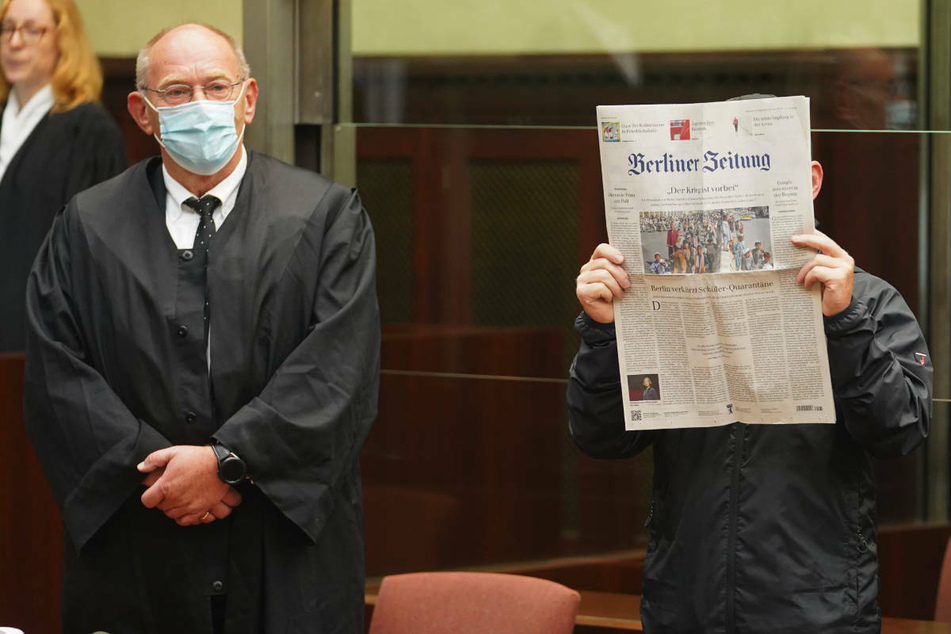 Jens F. (56, r.) steht am ersten Prozesstag neben seinem Verteidiger Friedrich Humke und hält sich eine Zeitung vor das Gesicht, um nicht erkannt zu werden.