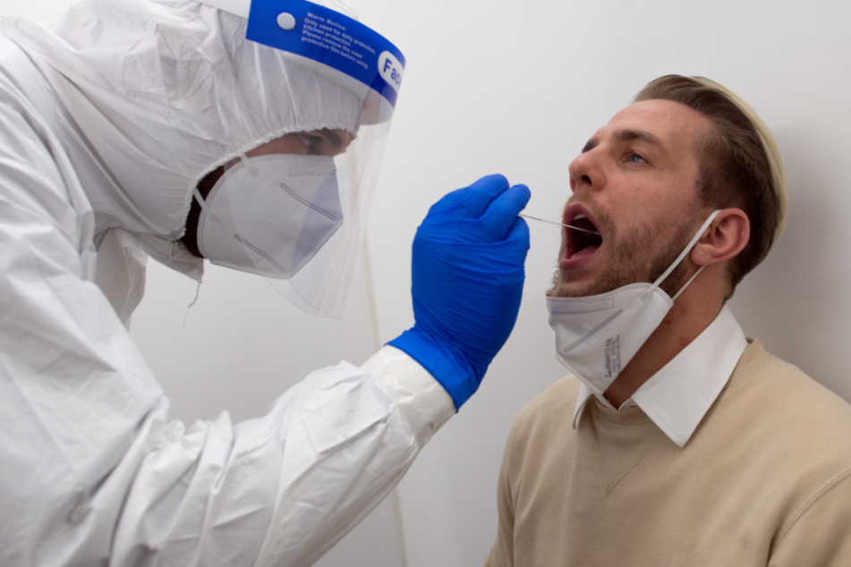 Ein Mitarbeiter des Covid 19-Schnelltest-Zentrums Düsseldorf nimmt bei einem Patienten eine Probe für einen Schnelltest. Corona-Schnelltests werden mittlerweile in mehreren Städten NRWs in extra hergerichteten Räumen angeboten.