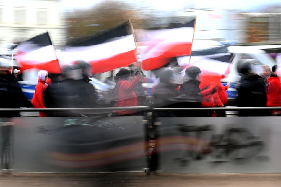 Teilnehmer einer Neonazi-Demonstration tragen Reichsflaggen durch die Straßen. (Symbolbild)
