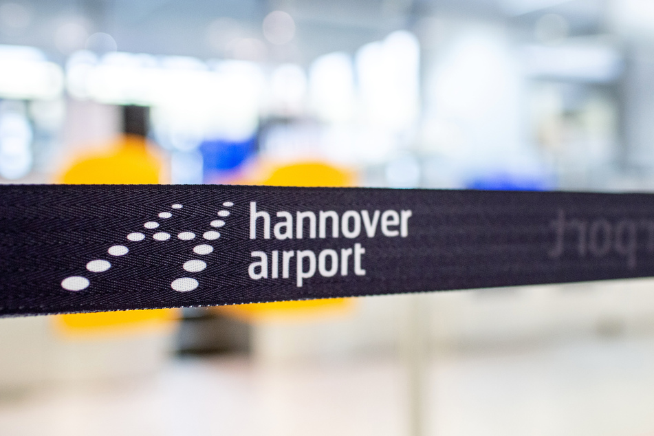 Ein Absperrband mit dem Logo des Flughafens hängt vor einem Check-in-Schalter in der Abflughalle des Flughafens Hannover.
