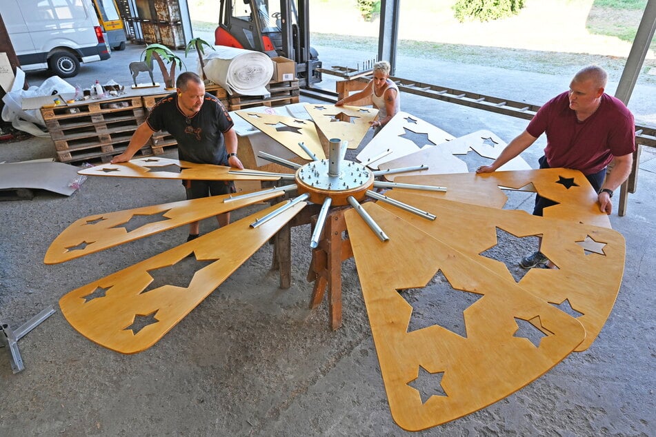 Die Mitarbeiter der Erzgebirgische Holzkunst Gahlenz stecken das Flügelrad zusammen.