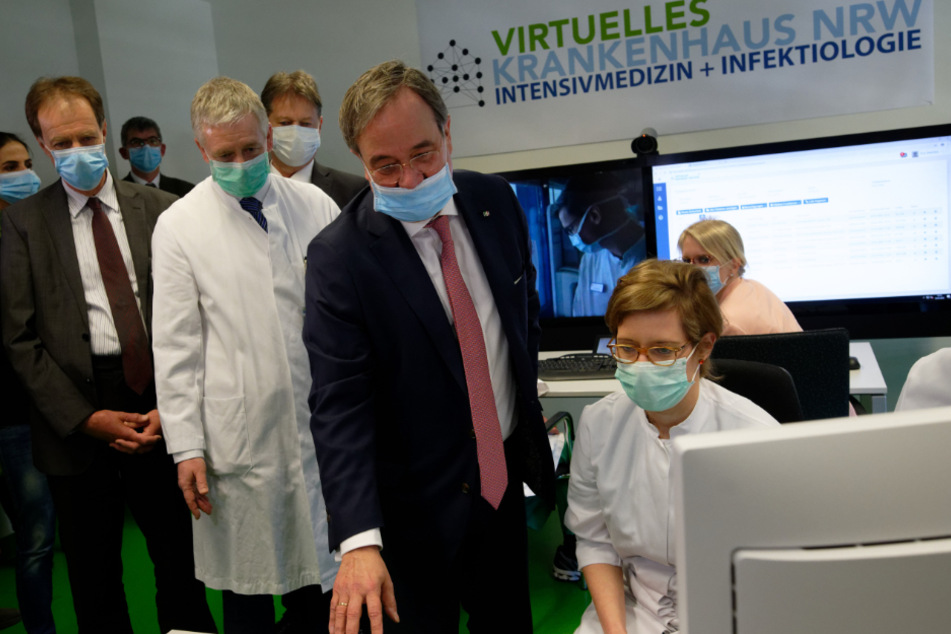 Armin Laschet (59, CDU, erste Reihe, 3.v.l), Ministerpräsident von Nordrhein-Westfalen, der aufgrund der Corona-Pandemie eine Mundschutzmaske trägt, verfolgt bei einem Pressetermin zum Start des Virtuellen Krankenhauses an der Uniklinik RWTH Aachen eine Behandlung in einem angeschlossenem Krankenhaus.