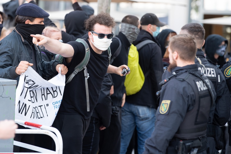 Ein Gegendemonstrant diskutiert während der Pegida-Kundgebung mit einem Polizisten.