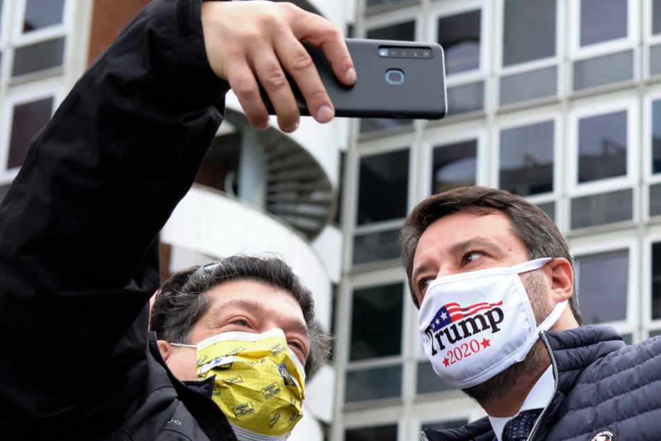 Matteo Salvini (47, rechts), der Chef der rechten italienischen Lega, lässt sich, mit einer Maske die für den US-Präsidenten Trump wirbt, fotografieren bei einem Protest gegen die Steuergesetze vor dem Sitz der Finanzbehörde.