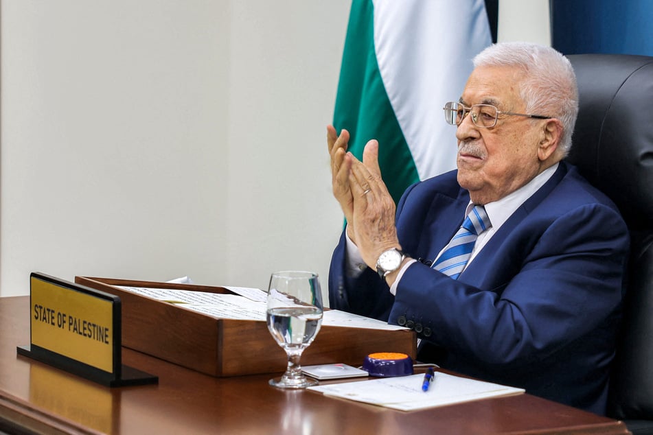 Palestinian Authority President Mahmoud Abbas applauds as he gives by video link an address to the UN summit on a two-state solution from his headquarters in Ramallah in the occupied West Bank on September 22, 2025.