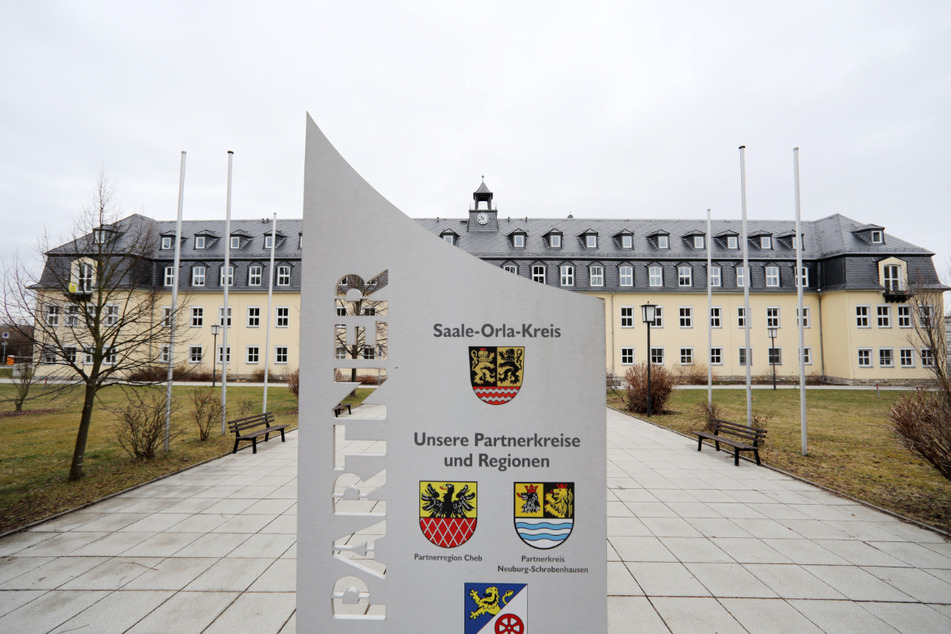 Ein Schild mit der Aufschrift "Saale-Orla-Kreis" steht vor dem Landratsamt. Der Landkreis im Südosten Thüringens will aufgrund der hohen Fallzahlen die aktuelle Ausgangsbeschränkung verlängern.