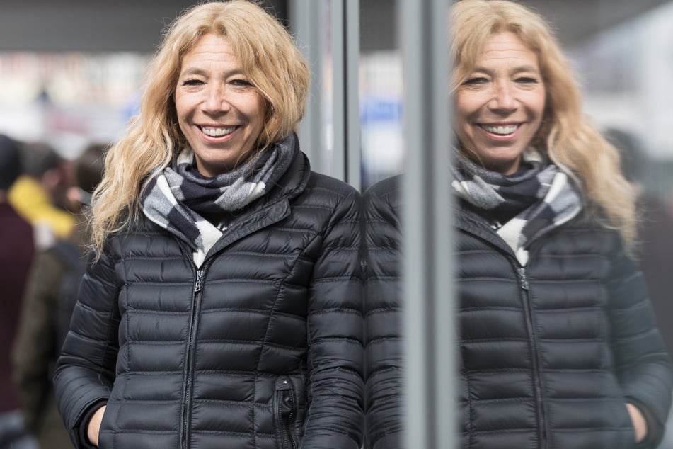 Die Initiatorin des Modellprojekts "Öffnen mit Sicherheit", Notärztin Lisa Federle, steht in der Tübinger Innenstadt vor einer Corona-Schnelltest-Station und spiegelt sich in einer Scheibe.