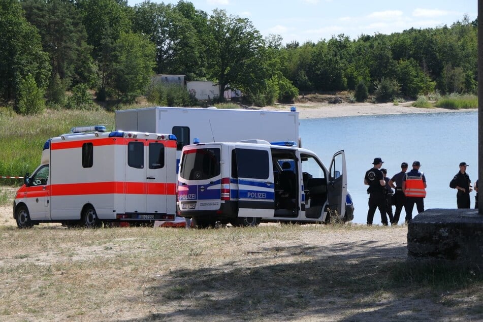 Kräfte von Polizei und Rettungsdienst am Dienstag am Moritzsee bei Naunhof, in dem seit Sonntag ein 19-Jähriger vermisst wird.