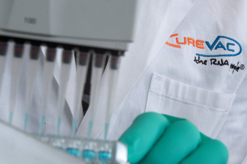 Ein Mitarbeiter des Tübinger Unternehmens CureVac gibt mit einer Pipette eine Lösung in ein Gefäß.