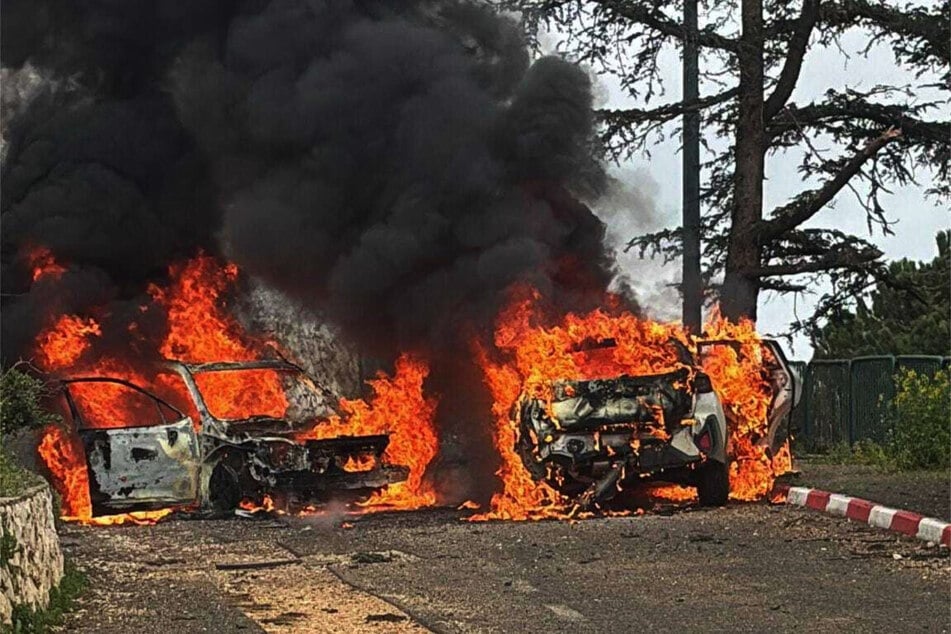 Während Feuerwehrkräfte brennende Fahrzeuge löschen, entdeckt der Rettungsdienst einen Toten.