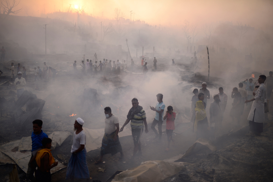 Zahlreiche ethnische Rohingya versuchen, ihre Habseligkeiten vor dem Brand in ihrem Lager zu retten.