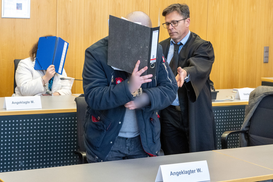 Im Landgericht weist Verteidiger Jan Schaufler (r.) seinem an den Händen gefesselten Klienten im Sitzungssaal seinen Platz auf der Anklagebank zu.