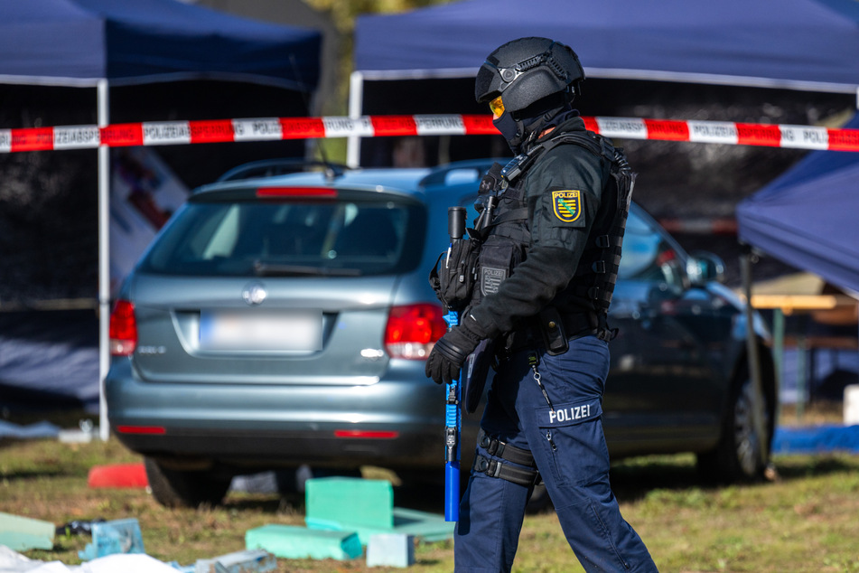 Ein Polizist sichert den "Tatort" in Zwickau mit einem Übungs-Gewehr ab. Bei der Polizeiübung wurde angenommen, dass ein Auto in eine Menschenmenge gerast ist.
