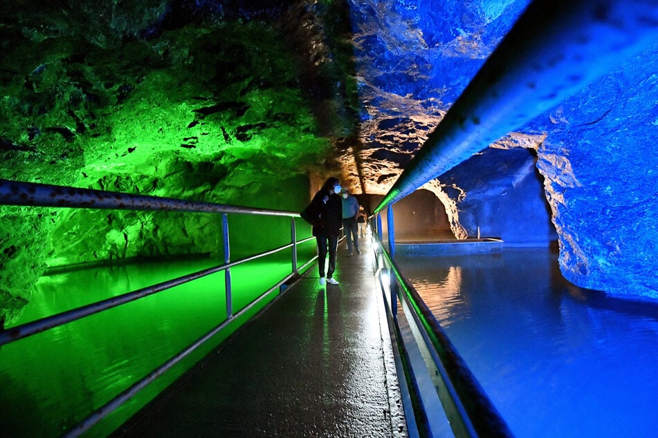 Die Marienglashöhle in Friedrichroda ist eine echte Sehenswürdigkeit. Dort laufen Besucher auf einem Steg in der farbig beleuchteten Höhle.