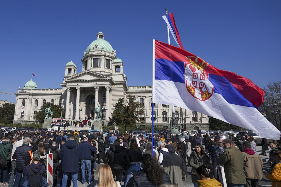 Während einer Sitzung des serbischen Parlaments gedenken Menschen schweigend der 15 Opfer, die im November 2024 beim Einsturz eines Betondaches des Bahnhofs im nordserbischen Novi Sad getötet wurden.