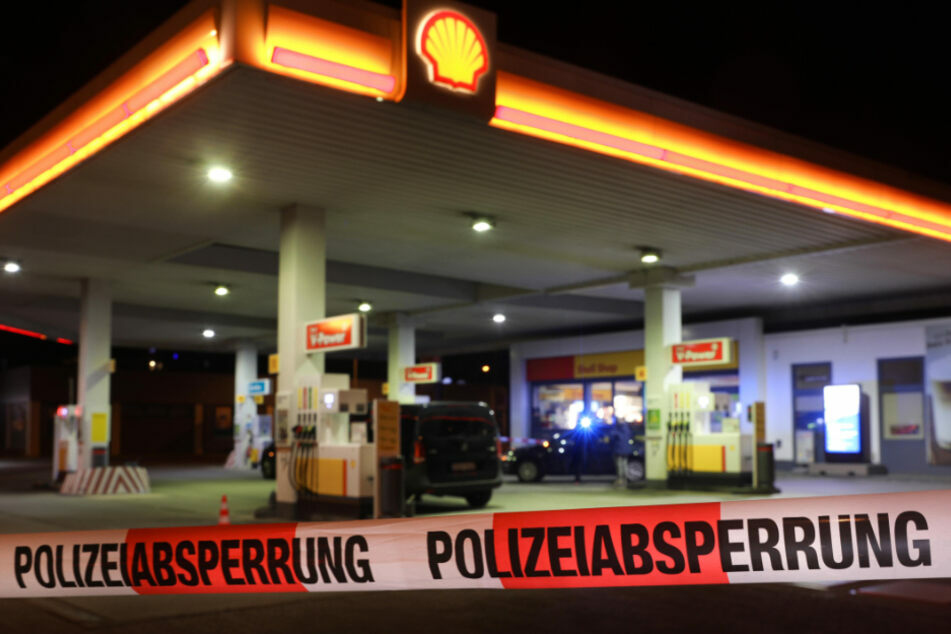 Geld erbeutet und Verkäufer mit Pistole bedroht: Polizei sucht Tankstellenräuber