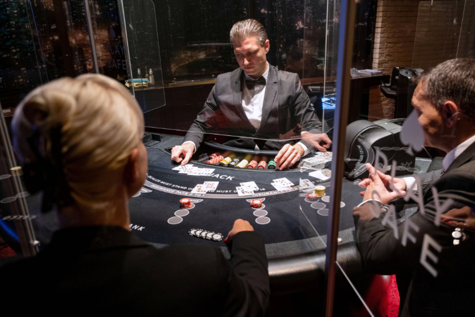Ein Croupier (M) gibt in der Spielbank Stuttgart während eines Pressetermins an einem Black Jack Tisch Karten aus.