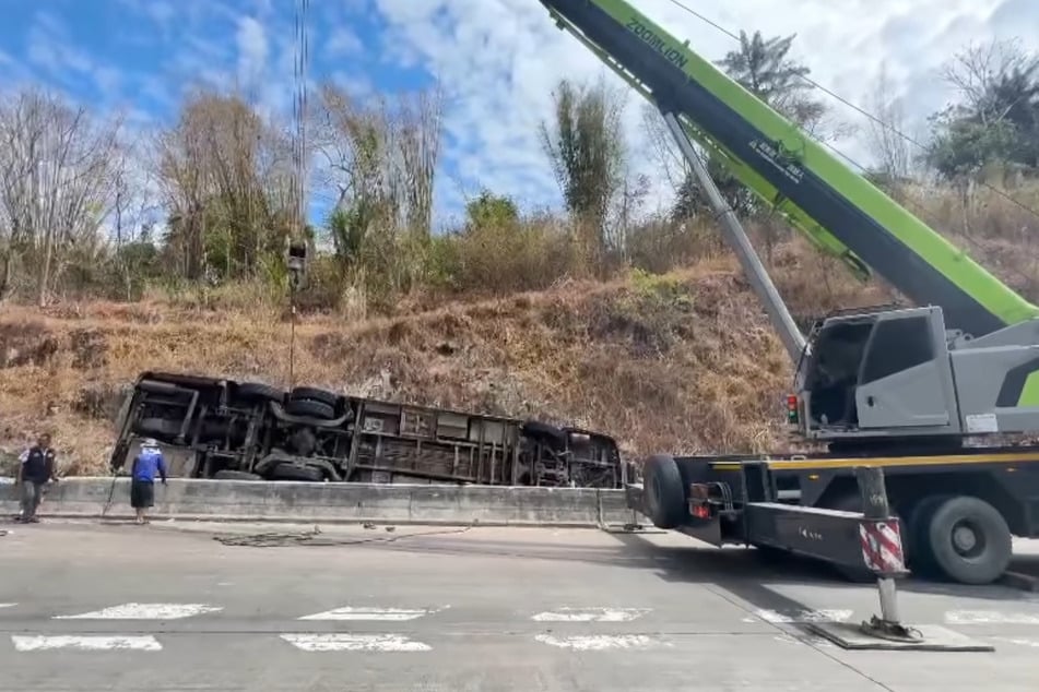 Ein Autokran hob das Buswrack aus dem Straßengraben.