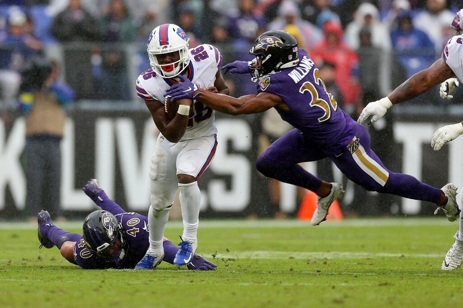 Devin Singletary of the Buffalo Bills runs with the ball while being chased by Marcus Williams of the Baltimore Ravens.