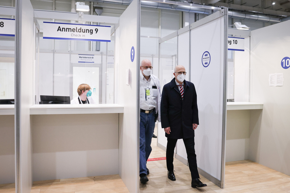 Peter Tschentscher (SPD, r) und Dirk Heinrich, ärztlicher Leiter des Impfzentrum Hamburg, gehen durch das Impfzentrum in den Messehallen.