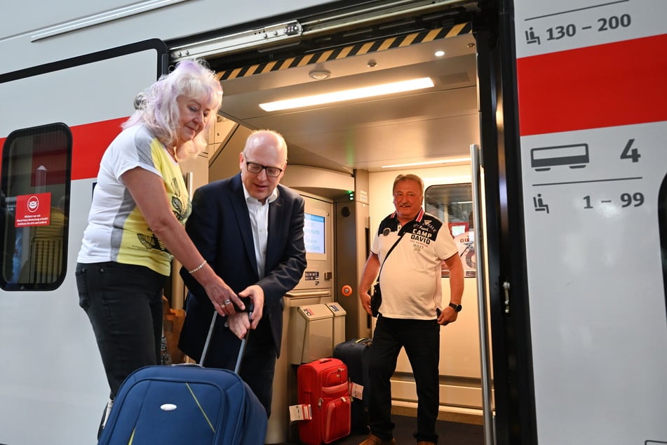 Oberbürgermeister Sven Schulze (50, SPD, M.) half Fahrgästen bei der Jungfernfahrt in den Zug.