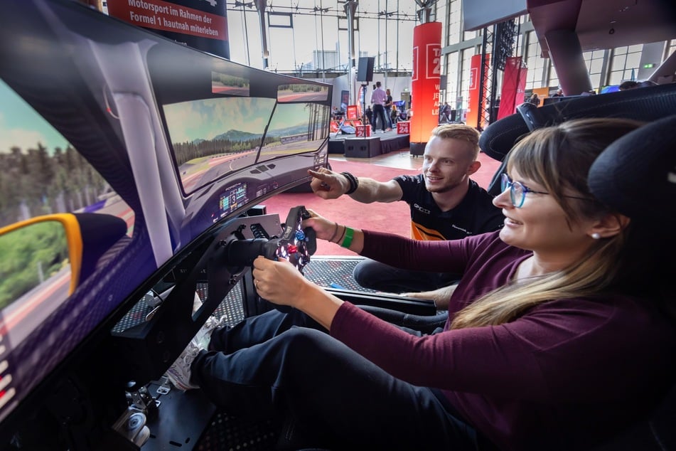 Rennfahrer Jonas Greif (24) erklärt Claudia den Rennsimulator.