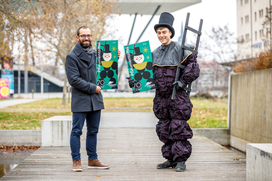 Alexander Hesse (37, l.) und "Pflaumentoffel" Anton Fuchs (22) zeigen die neue Weihnachts-Sonderbriefmarke.