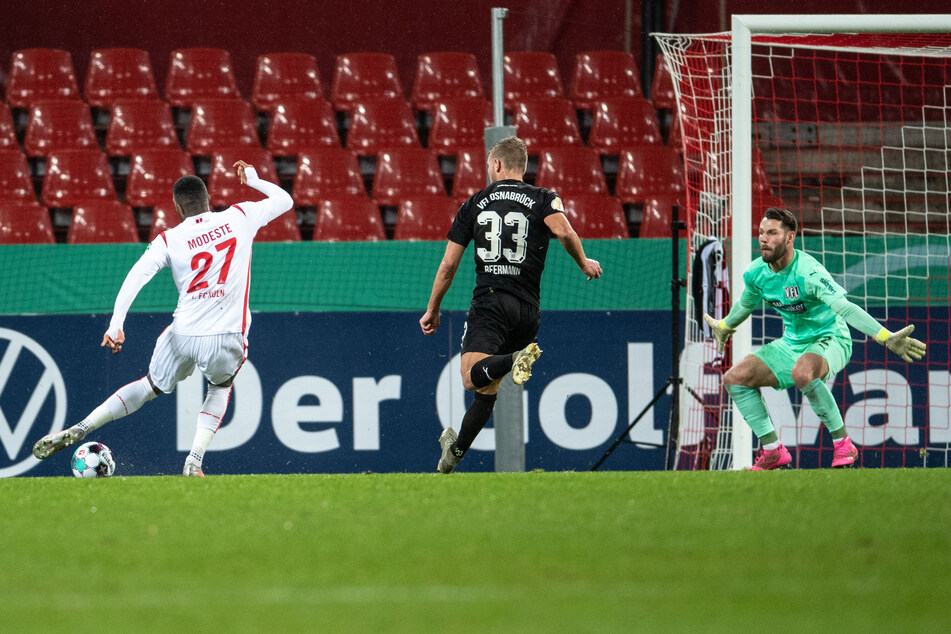 Kölns Anthony Modeste (l.) trifft gegen Osnabrücks Torhüter Philipp Kühn (r.) zur 1:0-Führung.