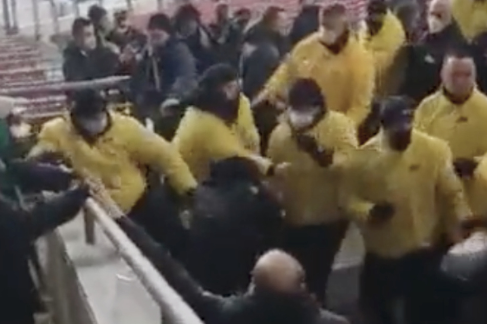 Die Ordner (in gelb) schlagen offenbar auf mehrere Fans in der Mercedes-Benz-Arena ein.