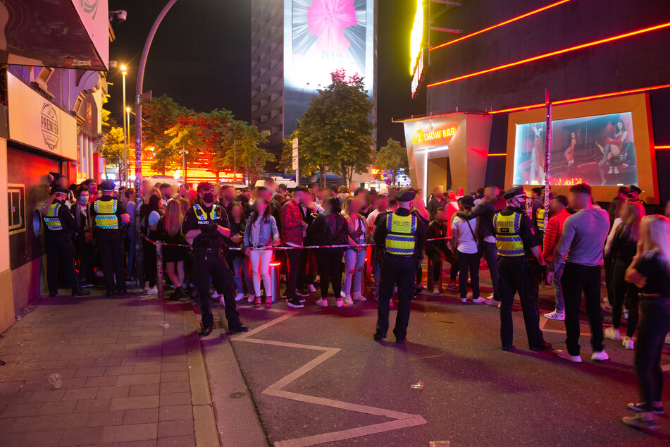 Dutzende Menschen stehen an dem gesperrten Eingang zur Großen Freiheit.