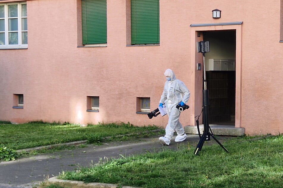 Ein Kriminaltechniker kommt nach der Dokumentation des Tatortes aus dem Wohnhaus, in dem der Mord geschah.