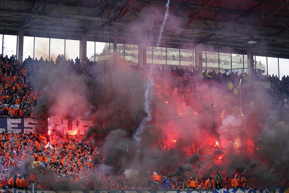 Rostocks-Fans brennen auf der Tribüne Pyrotechnik ab.
