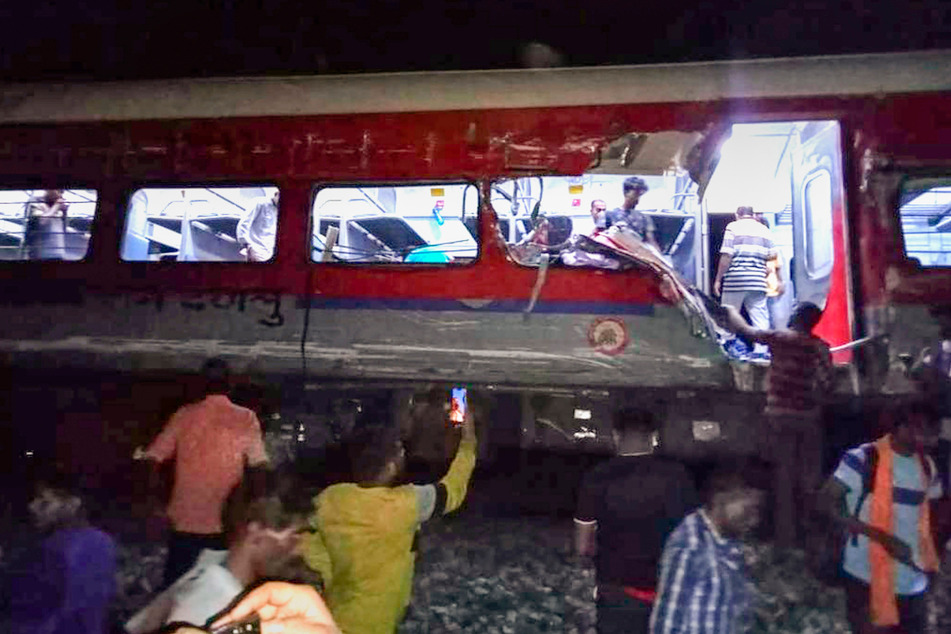 Menschen inspizieren den Ort der entgleisten Personenzüge im Bezirk Balasore.