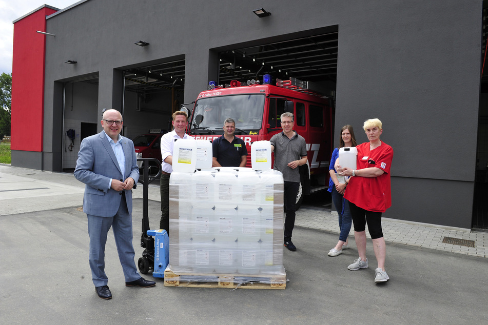 Sven Schulze (48, SPD, l.), Marc Kusche (46, Wernesgrüner), Jens Kreißig (51, Feuerwehr), Ralph Burghart (50, CDU), Saskia Quinge (30, Sozialamt) und Simone Maulana (55, Heim gGmbH). Die Übergabe von 1800 Litern Desinfektionsmittel fand am neuen Gerätehaus der Feuerwehr in Glösa statt.