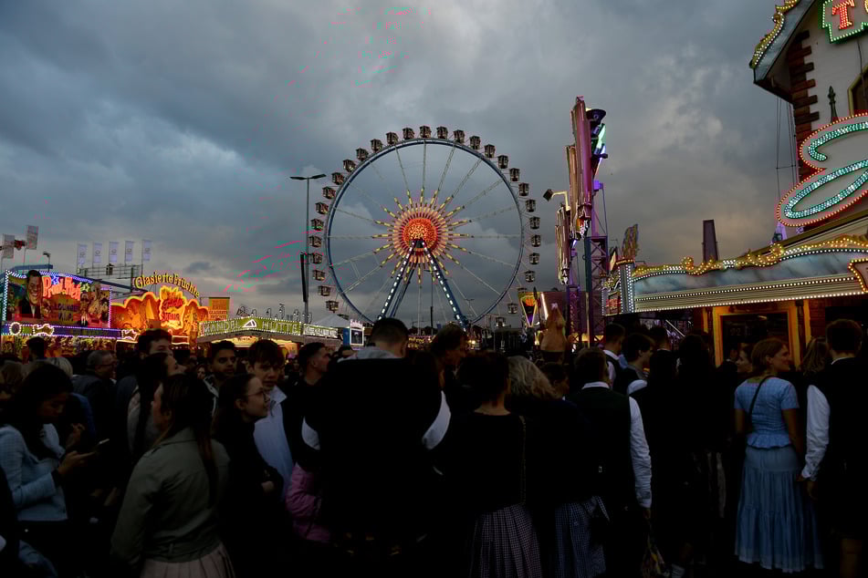 Dunkler Wolken ziehen über dem Oktoberfest auf. Bisher sind vergleichsweise weniger Besucher als letztes Jahr gekommen.