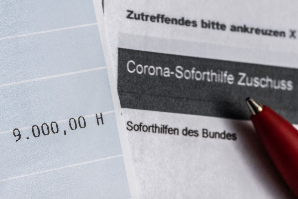 Ein Kontoauszug mit der überwiesenen Summe von 9000 Euro Corona-Soforthilfe liegt auf einem Antrag für den Zuschuss der Sächsischen Aufbaubank.