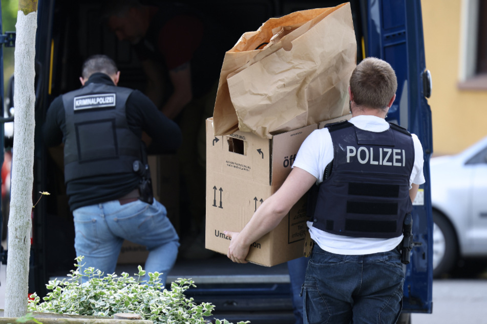 Die Beamten trugen mehrere Kartons aus der Wohnung in einen Lieferwagen.